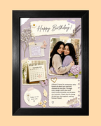 A framed personalized birthday collage with a black frame, featuring a lavender background, decorative paper cutouts, butterflies, flowers, a small calendar, and a printed photo of two women. The collage includes the text 'Happy Birthday!' and a heartfelt message, set against a solid pale peach background.
